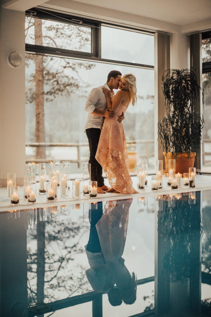 Couple next to a romantic pool lit by candle light