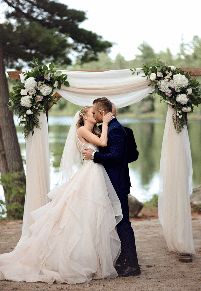 Groom Kissing Real Bride Wearing Ruffled Wedding Gown Called Amelie by Sottero and Midgley