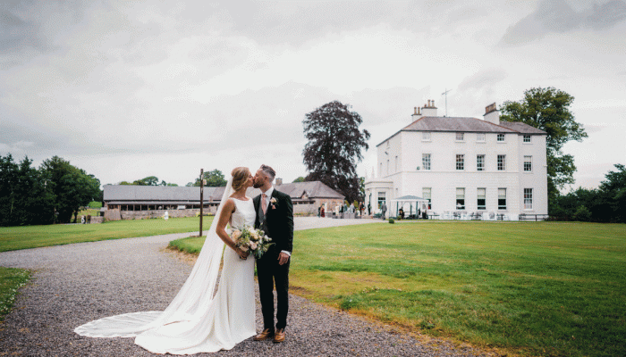 Groom Kissing Real Bride Wearing Simple Wedding Dress Called Evangelina by Maggie Sottero