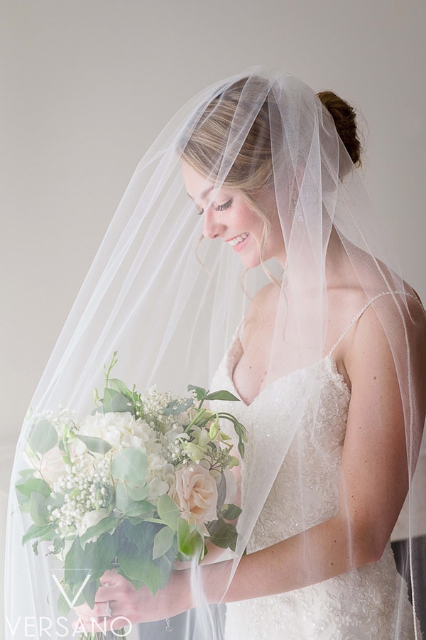 Real Bride Wearing Sheath Wedding Dress Called Nola by Sottero and Midgley and holding White Bouquet