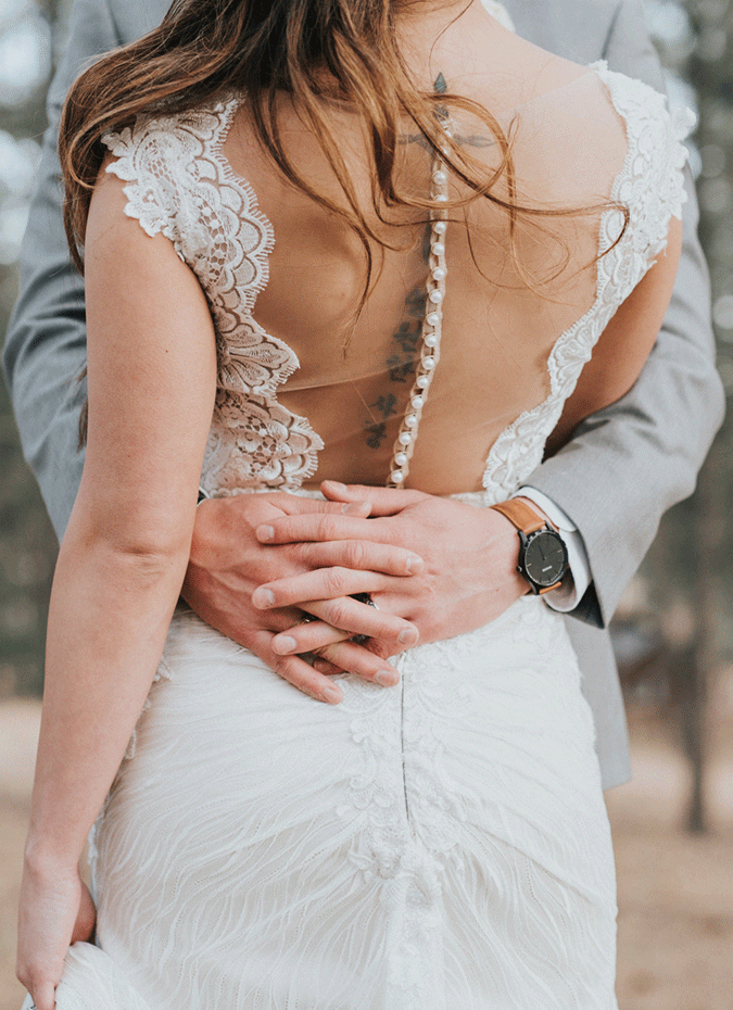 Groom Hugging Bride Wearing Backless Wedding Gown Called Wyatt by Sottero and Midgley