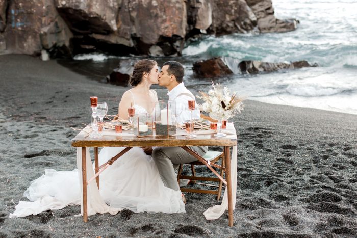 Real Bride and Groom sitting at Reception Table at Intimate Beach Wedding on a Black Sand Beach