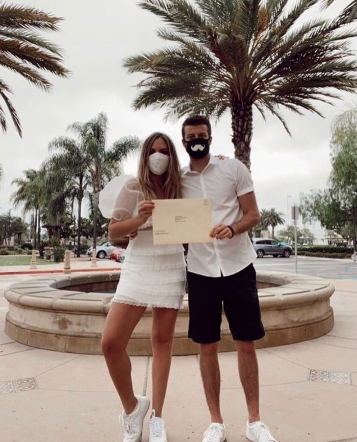 Singer Michelle Ray with Her Fiancé Holding Their Marriage Certificate While Wearing Masks 