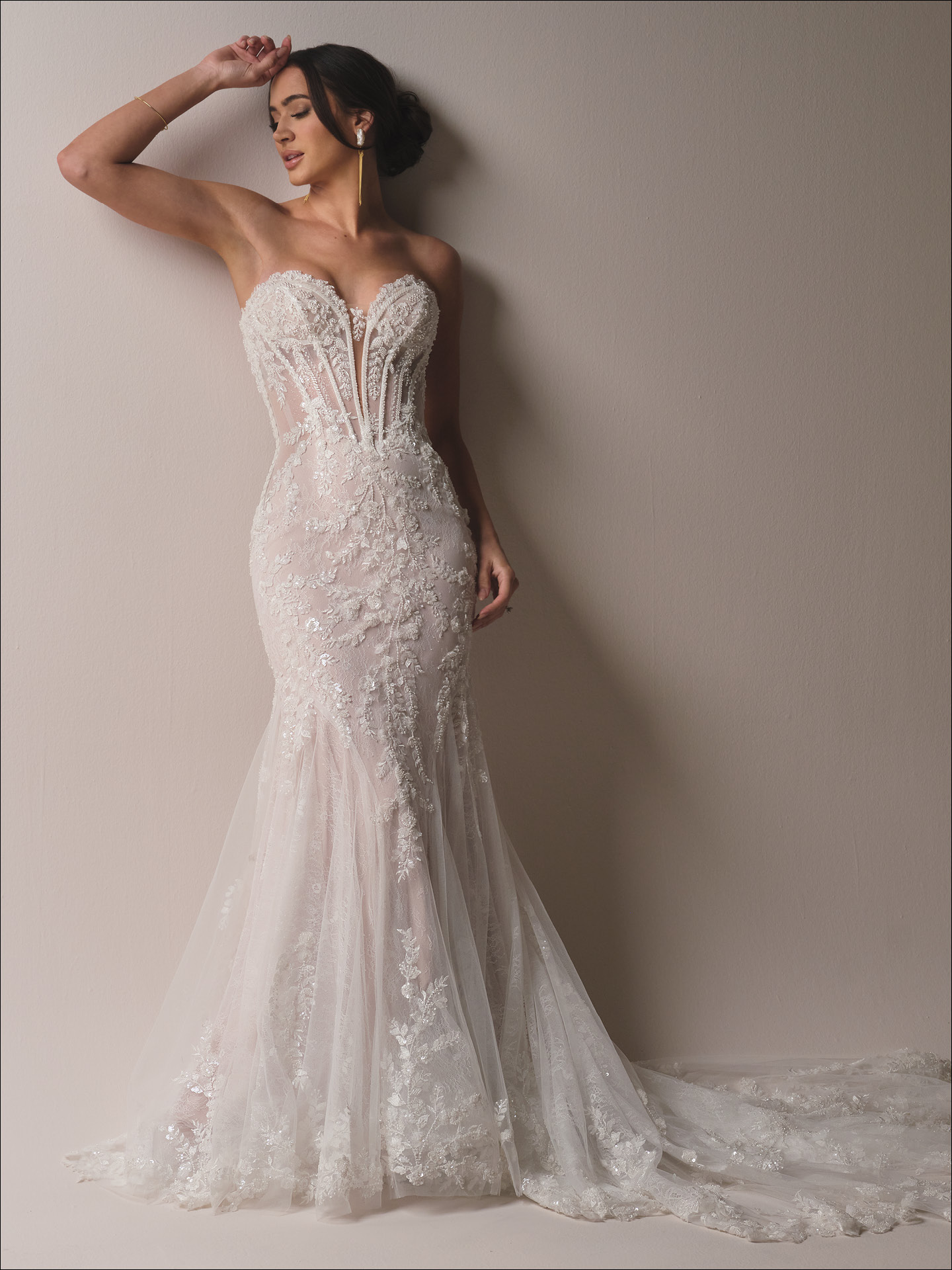 Benjie Royale fit-and-flare wedding dress featuring a shimmering lace silhouette with a plunging illusion sweetheart neckline, sculpted corset bodice, and soft tulle train adorned with intricate floral appliqués