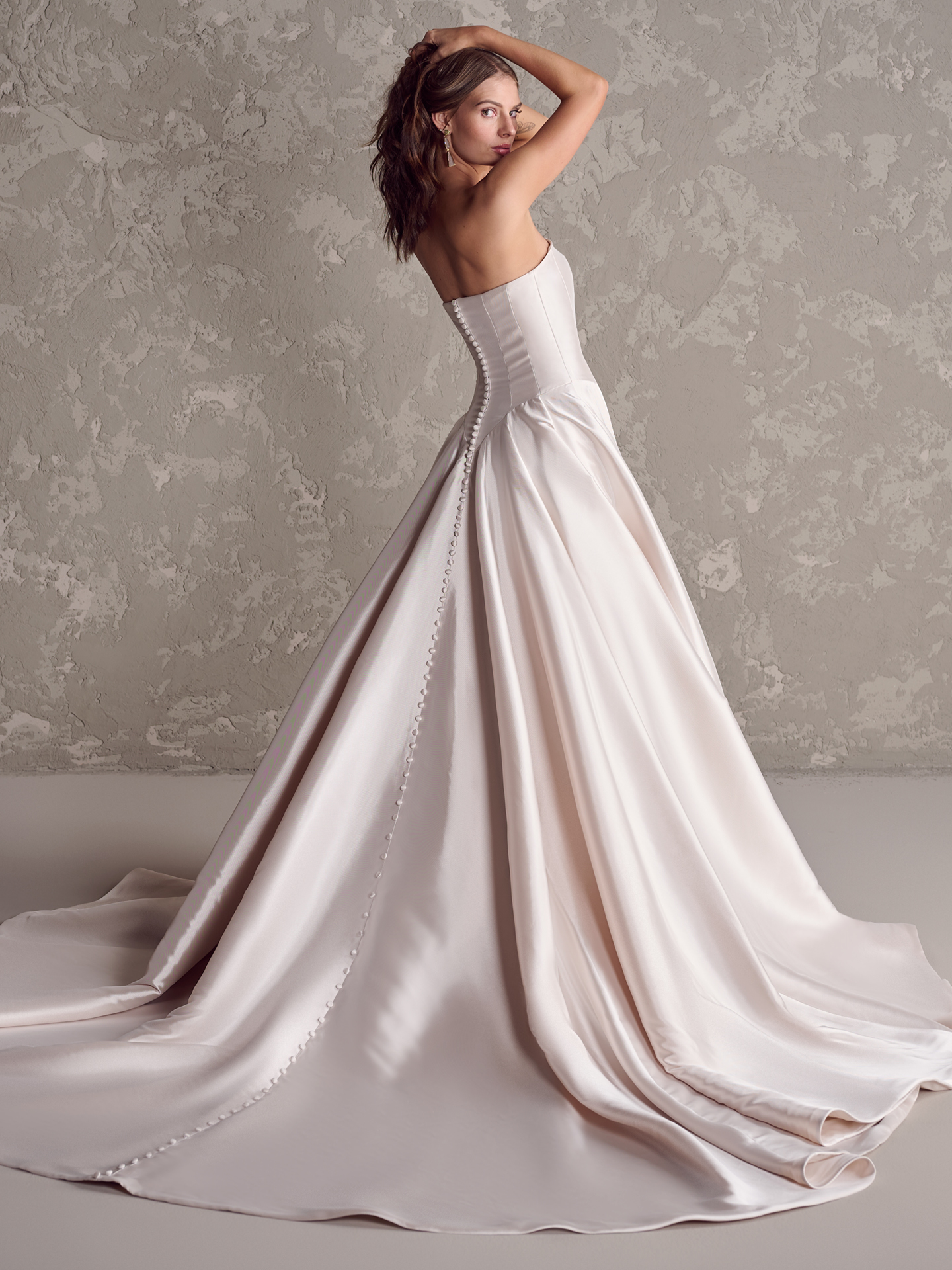 Emmanuelle ballgown wedding dress back view with strapless corset bodice, covered button closure, and a sweeping satin train for a classic, refined finish