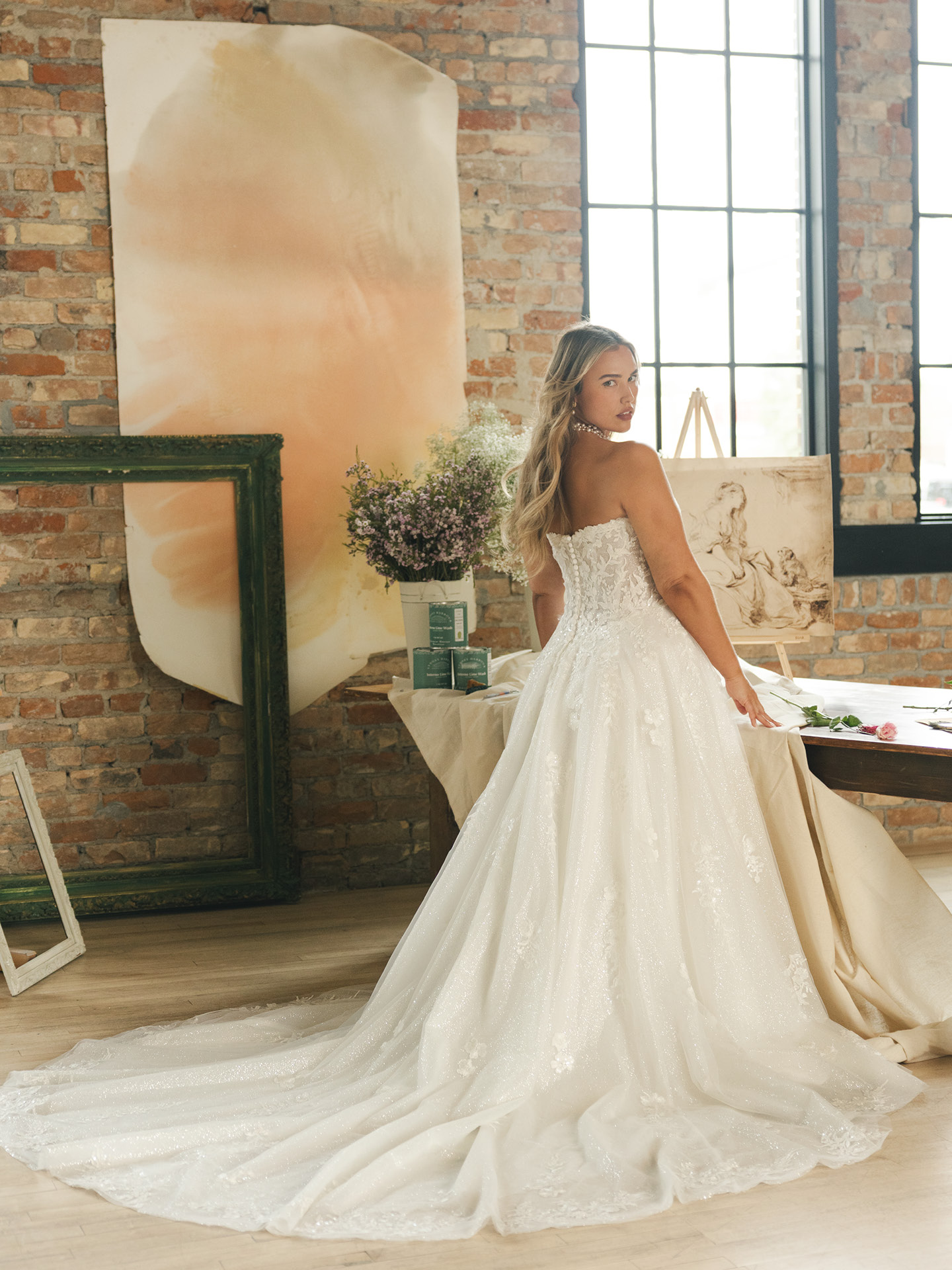 Jennifer ballgown wedding dress back view with strapless lace bodice, soft shimmer tulle skirt, and a sweeping train with delicate floral appliqués