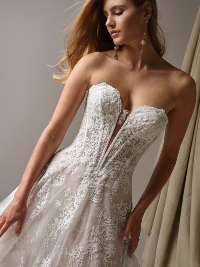 Lucca A-line wedding dress close-up of strapless lace bodice with illusion plunge detail, intricate floral lace, and delicate texture for a feminine, modern look