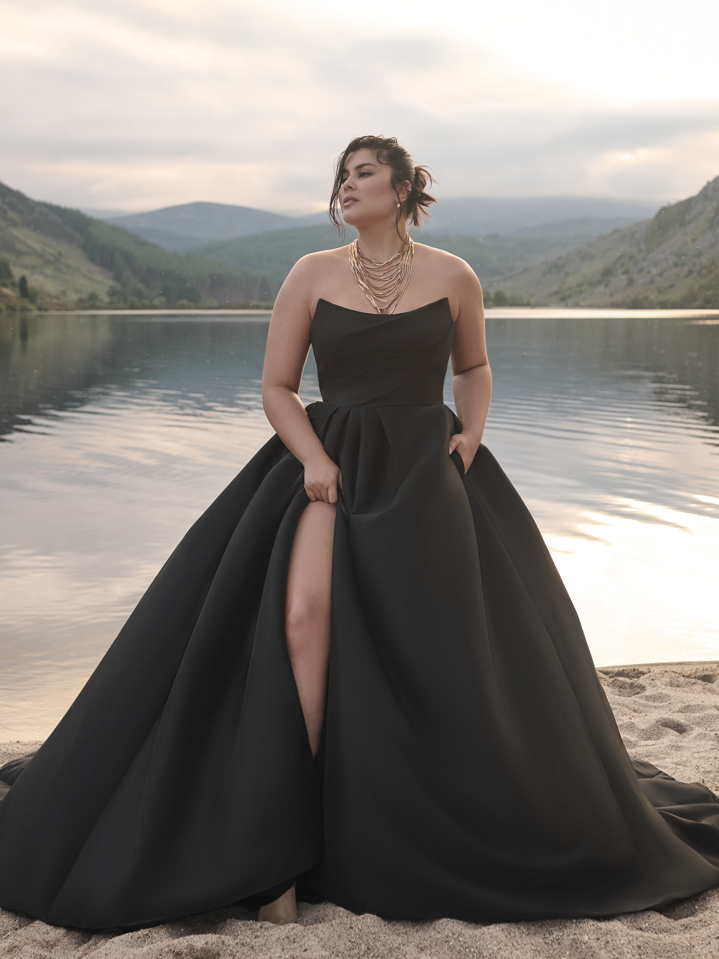 Aspen A-line wedding dress in black featuring a strapless straight neckline, structured satin bodice, and full skirt with a thigh-high slit, styled for a modern outdoor bridal look