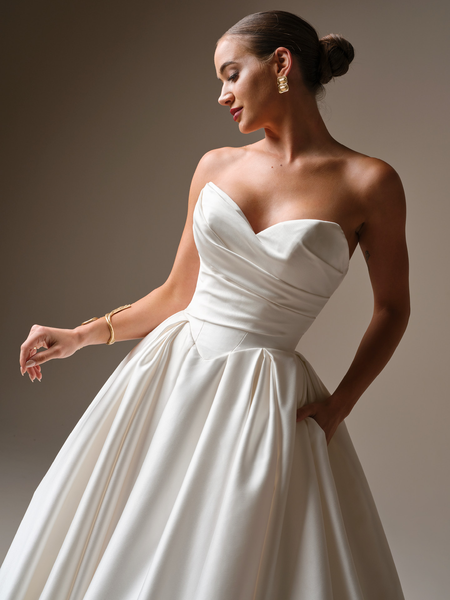 Elias ballgown wedding dress close-up of strapless sweetheart bodice with soft draping, defined waist, and voluminous satin skirt with clean, modern pleats