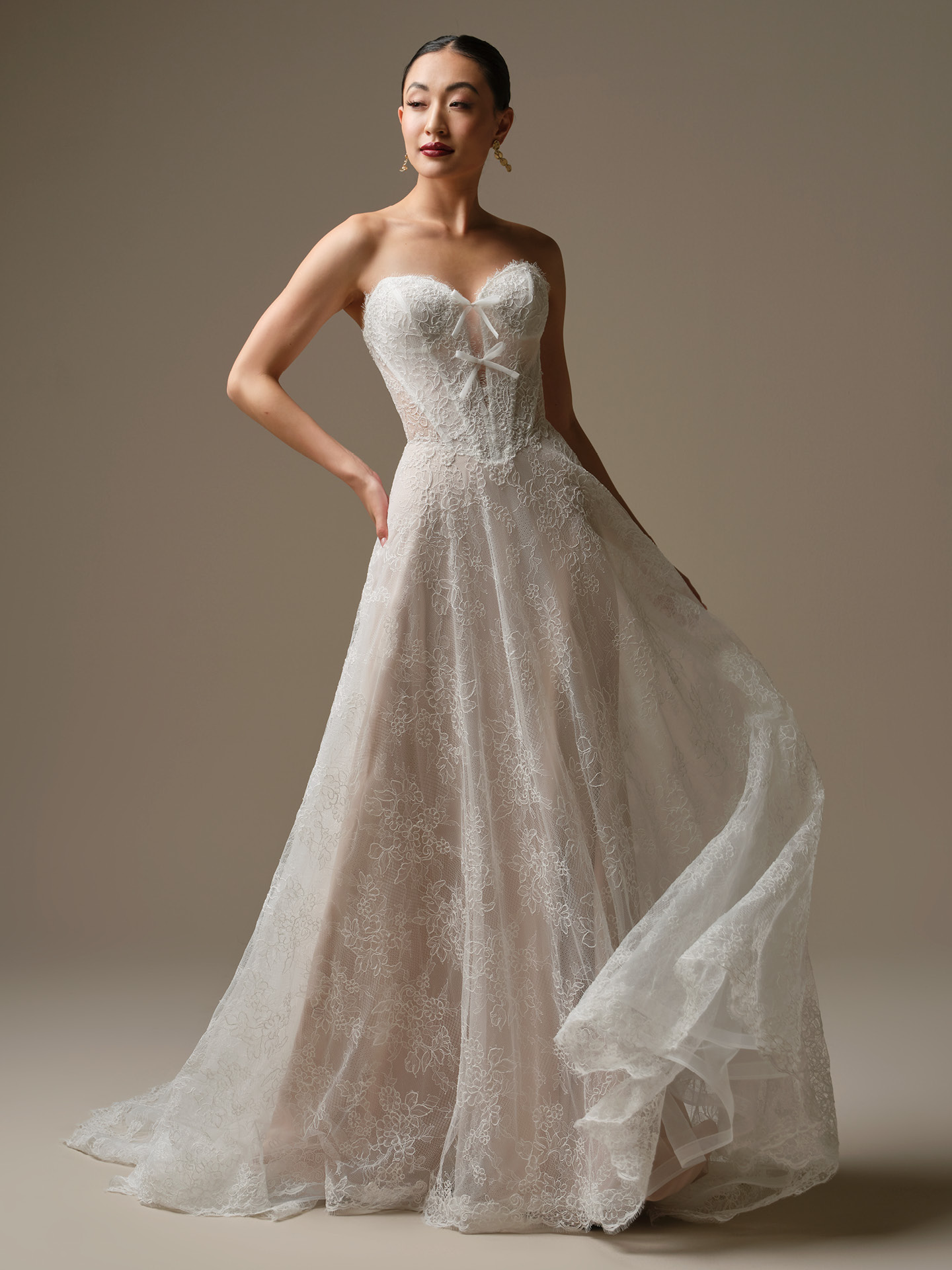 Granger A-line wedding dress featuring a strapless sweetheart neckline, sheer lace bodice with delicate bow accents, and a flowing allover lace skirt for a soft, romantic silhouette