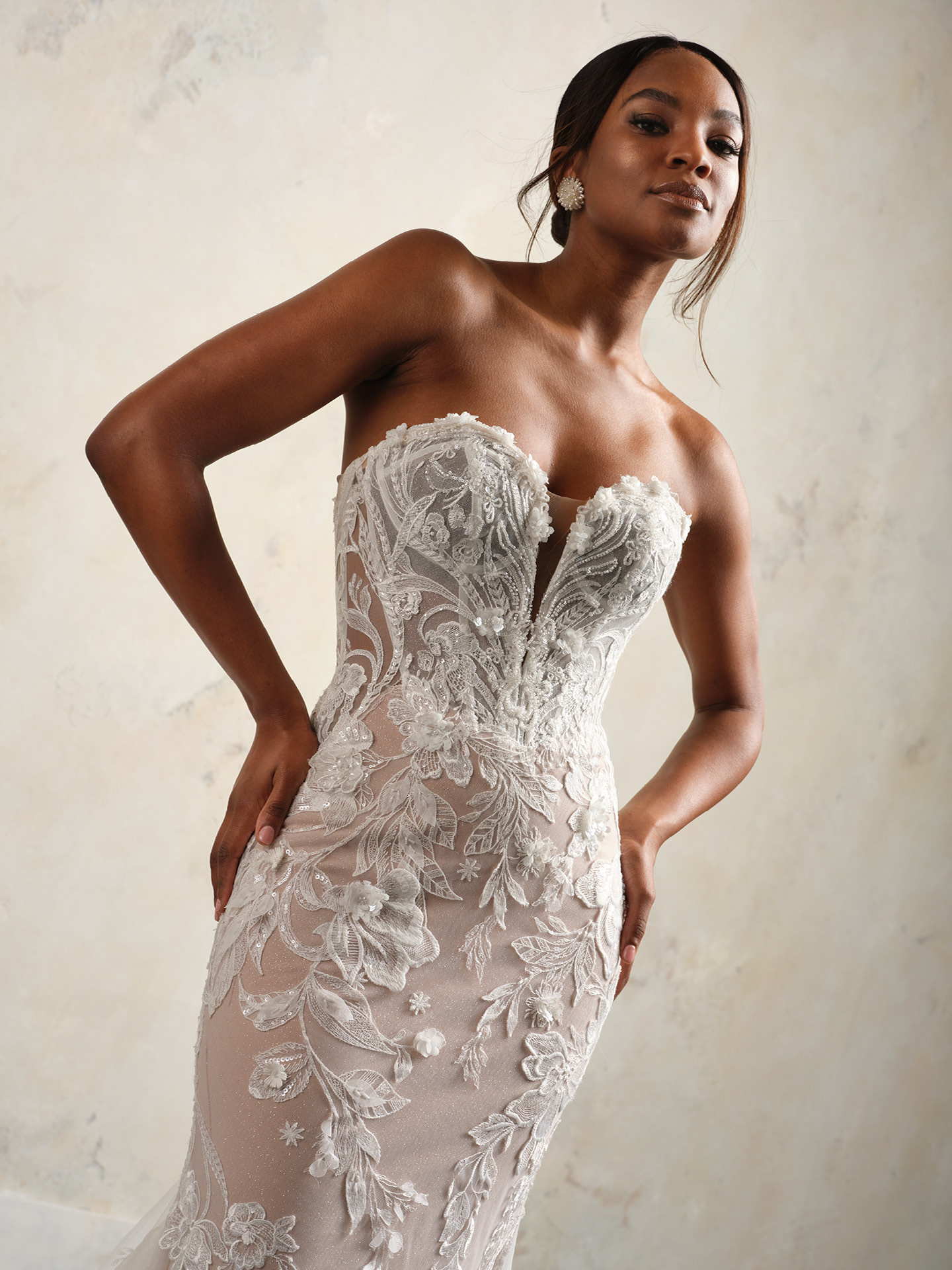 Nyjah strapless lace wedding dress bodice with a deep illusion plunge, textured floral appliqué, and delicate beaded detailing over a sheer corset structure