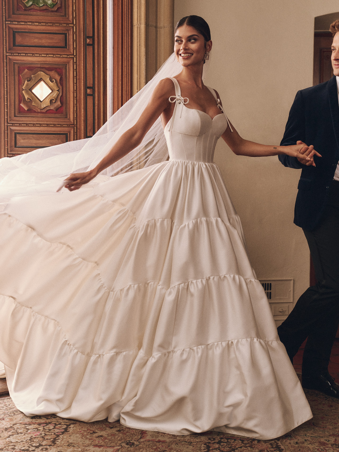 Talitha ballgown wedding dress featuring a structured corset bodice with tie straps, sweetheart neckline, and tiered satin skirt for a romantic, voluminous silhouette