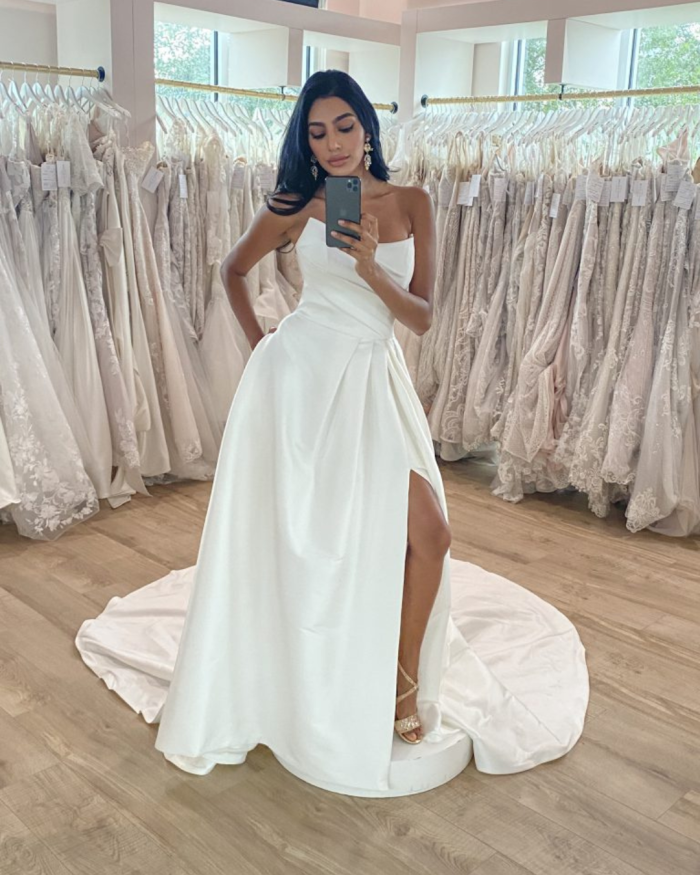 Bride trying on Maggie Sottero wedding dresses at a bridal boutique