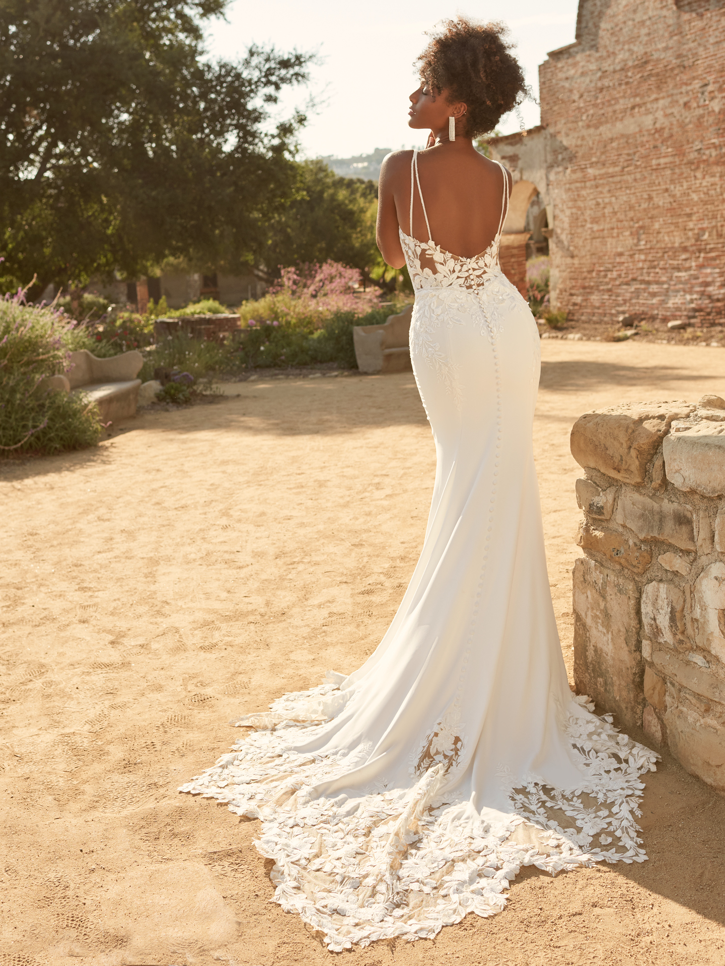 Mariée à l'arrière portant une robe de mariée en crêpe fourreau appelée Baxley par Maggie Sottero
