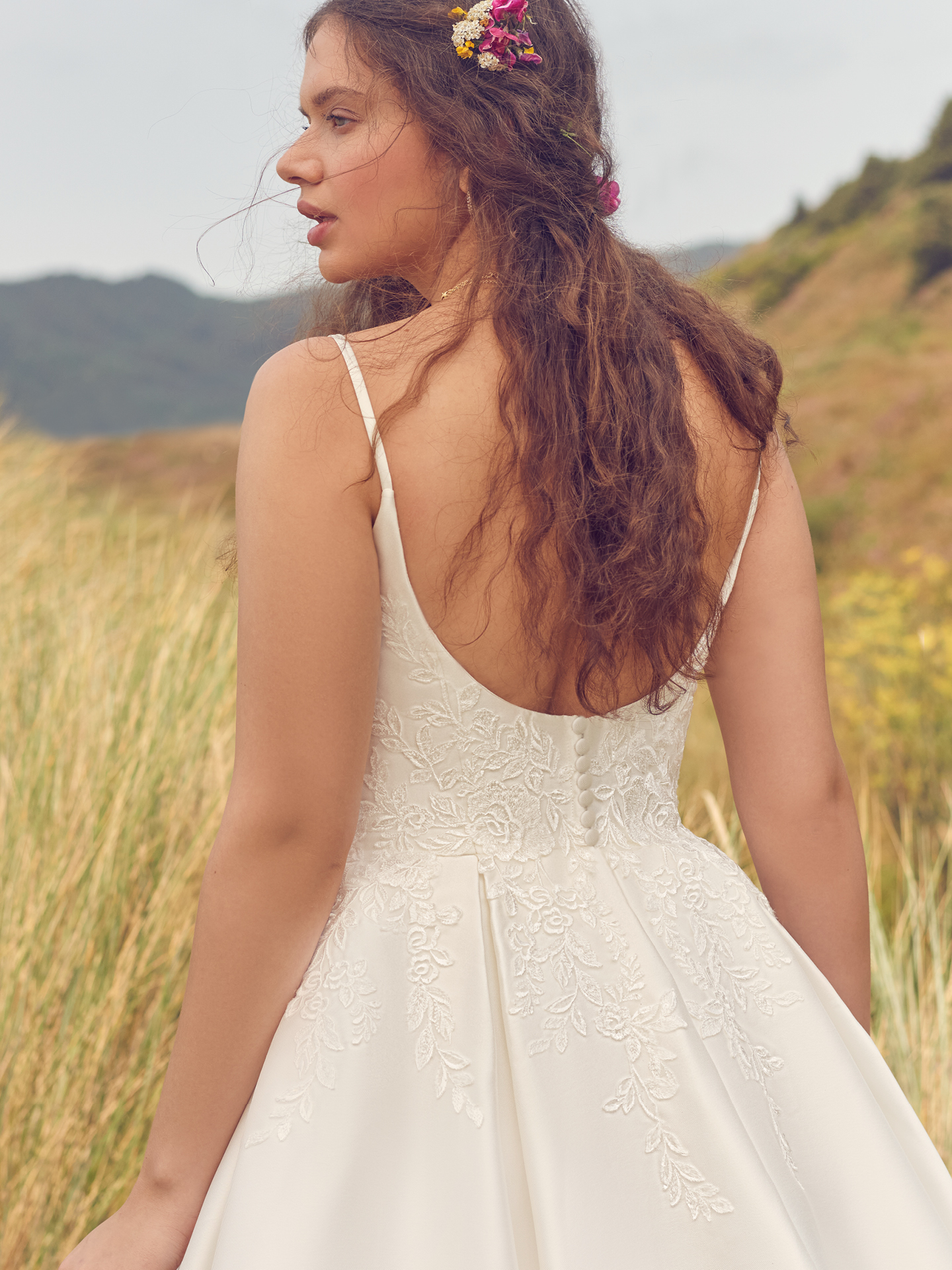 Mariée à l'arrière portant une robe de mariée trapèze en satin appelée Iona par Rebecca Ingram