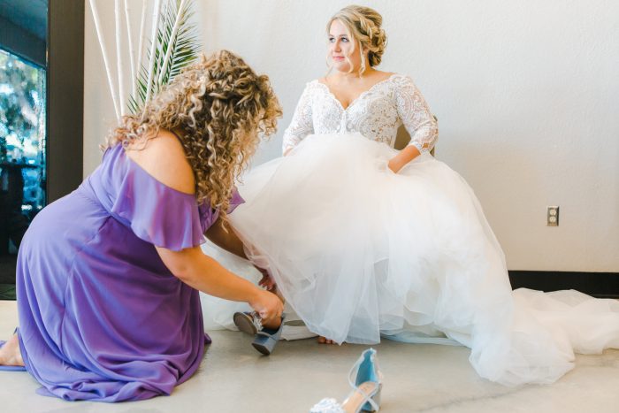 Bridesmaid Helping Real Bride Put Her Spring-inspired Pastel Wedding Shoes on for Her Wedding