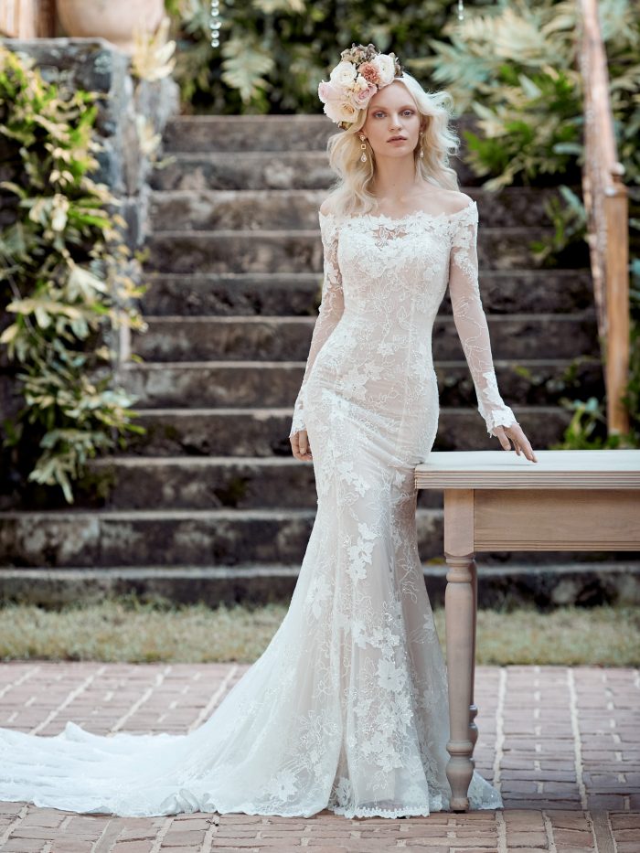Model Wearing Off-the-Shoulder Backless Sheath Wedding Dress Called Emiliano by Maggie Sottero