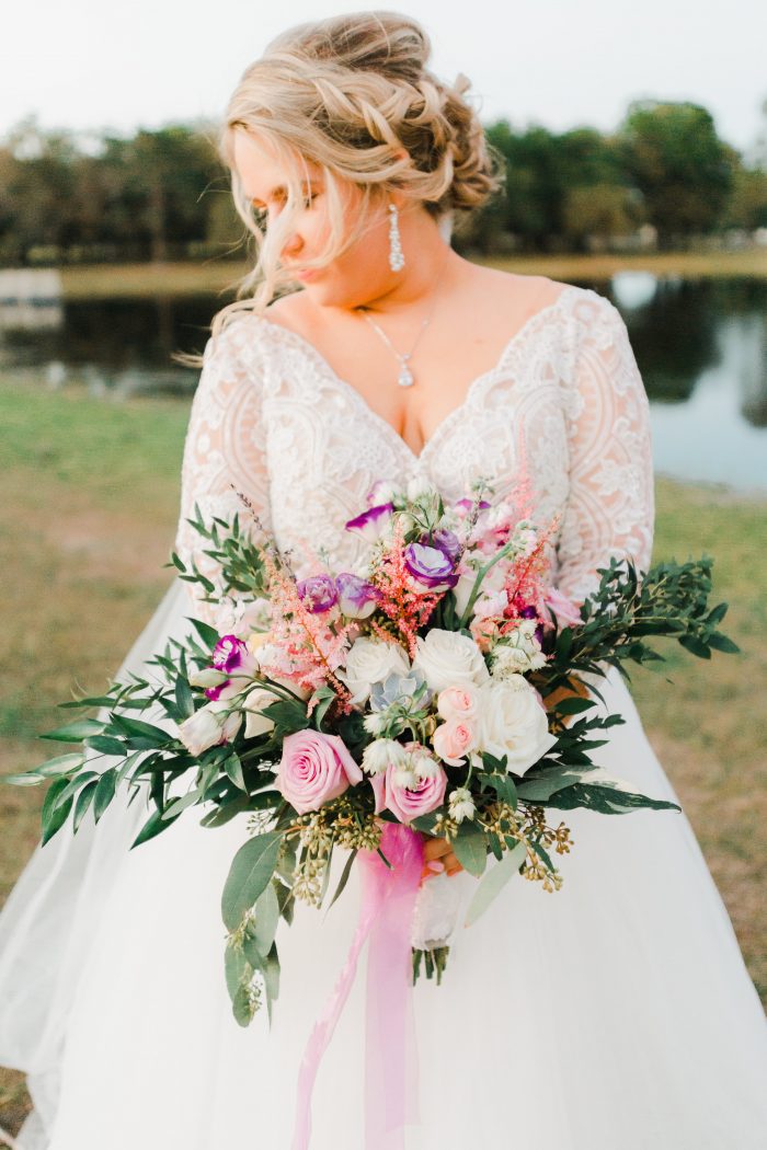 Real Curvy Bride Holding Colorful Bouquet and Wearing Illusion Lace Ball Gown Wedding Dress Called Mallory Dawn by Maggie Sottero