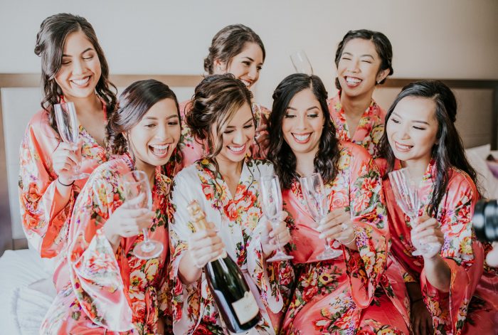 Real Bride with Bridesmaids Popping Open a Bottle of Champagne on Her Wedding Day