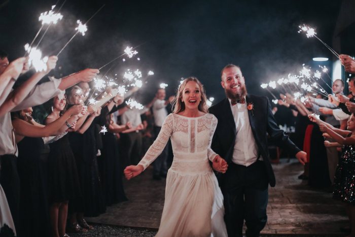 Groom with Real Bride Running Through Sparklers After Evening Reception