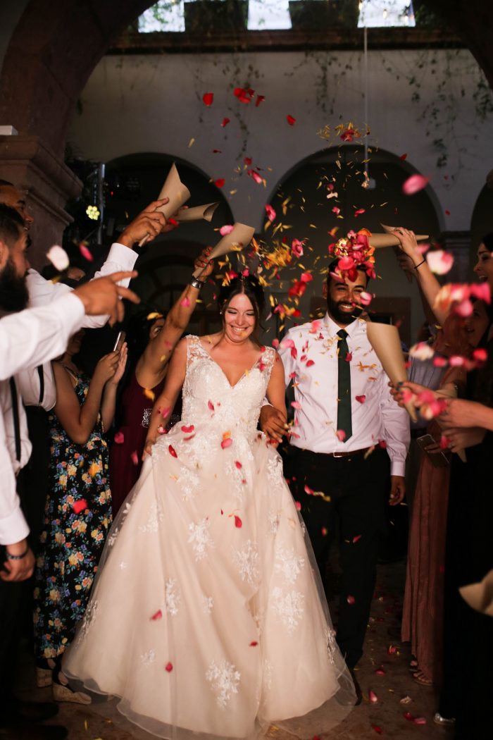 Bride and Groom Walking Through Rose Petals Confetti During Wedding Recessional