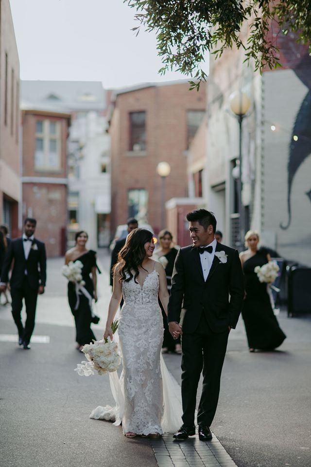 Groom Walking with Real Bride Wearing Tuscany Lace Wedding Dress During Multicultural Wedding