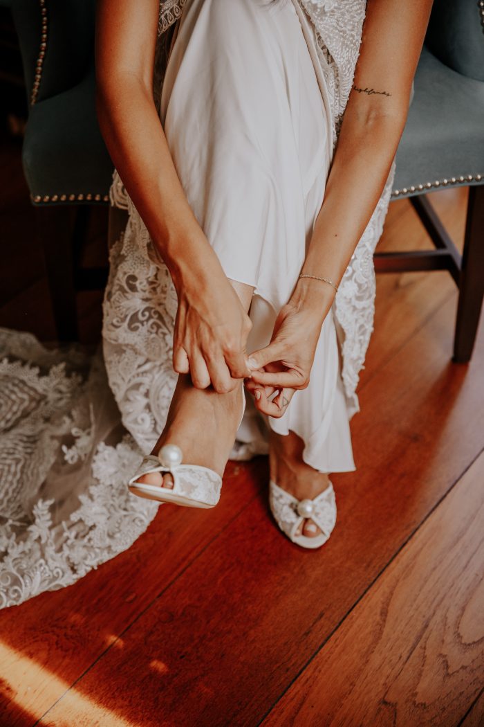 Bride Putting on Pearl Accented Open Toe Shoes for Wedding