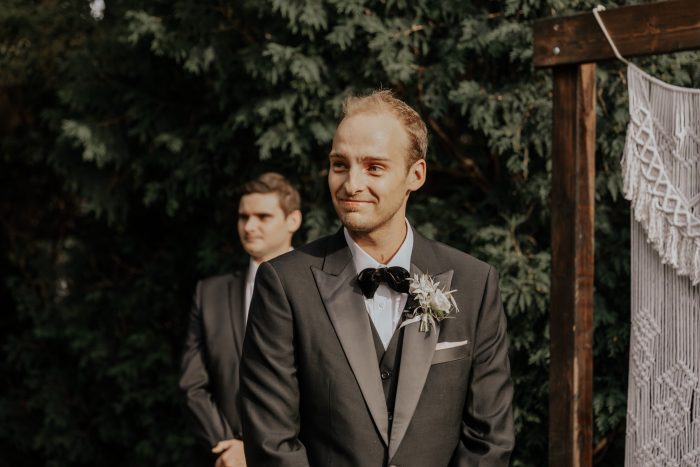 Groom Watching Bride Walk Down the Aisle at Boho-Chic Backyard Elopement