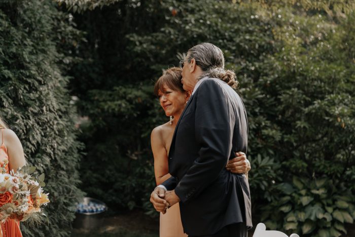 Mother and Father of Bride Watching Bride's Ceremony During Backyard Elopement