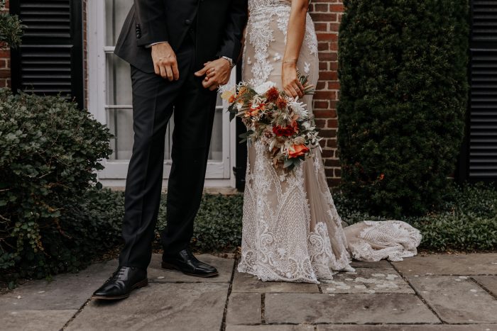 Groom with Bride Wearing Boho Wedding Dress and Holding Colorful Boho Wedding Bouquet