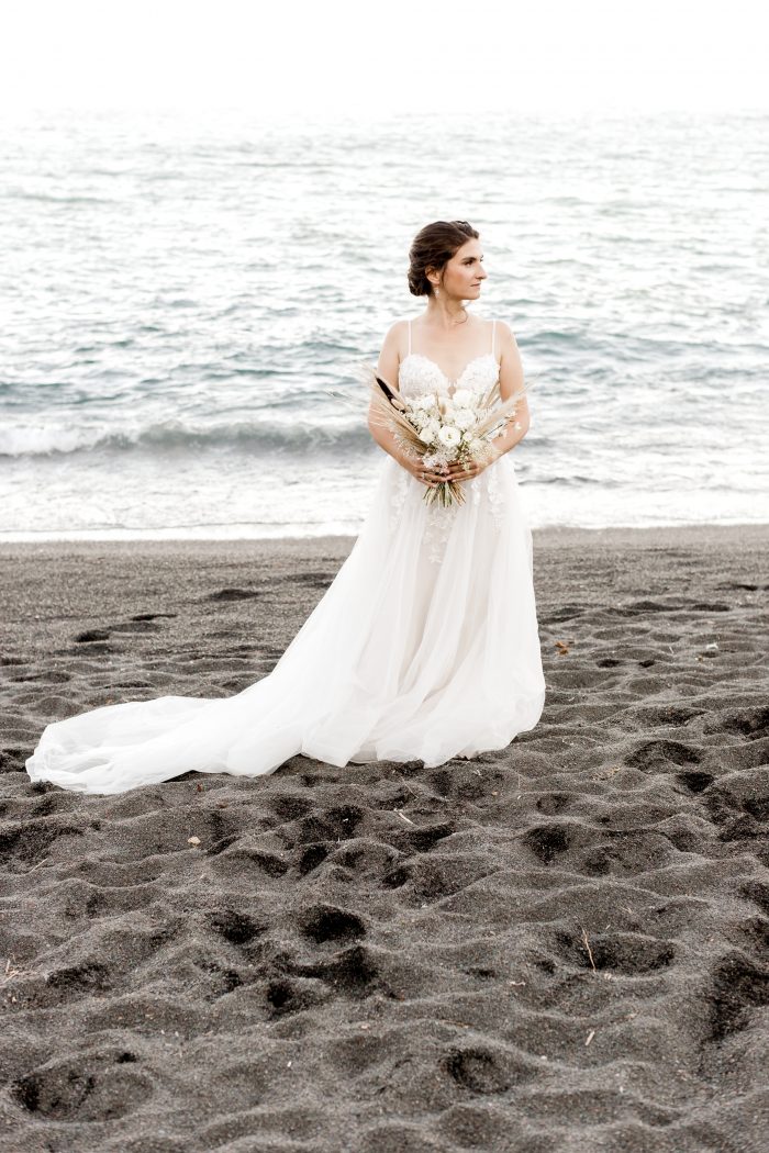 Real Bride on Beach Wearing Boho Beach Wedding Dress and Holding White Bouquet