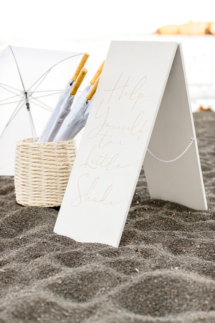 Sign with Umbrellas for Guests at Beach Elopement