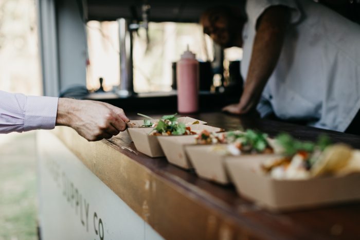 Guest Grabbing Serving of Homemade Tacos from Taco Truck at Wedding Reception