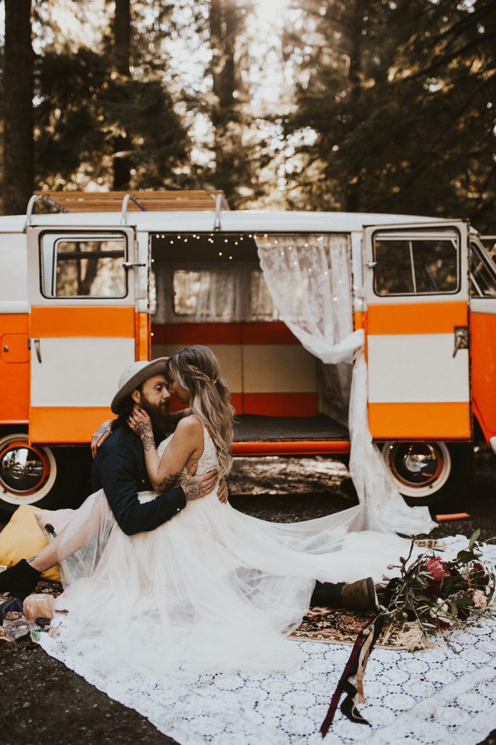 Groom Sitting in Front of Hippie Van with Bride Wearing Boho Bridal Gown Called Charlene by Maggie Sottero