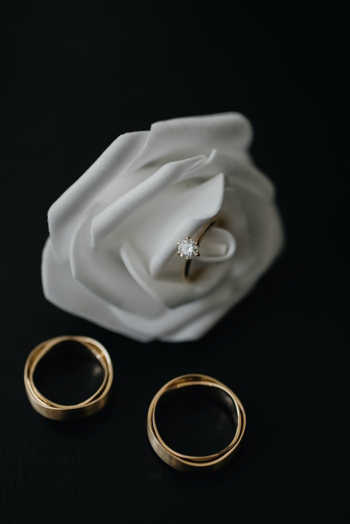 Wedding Ring On Top of White Rose 