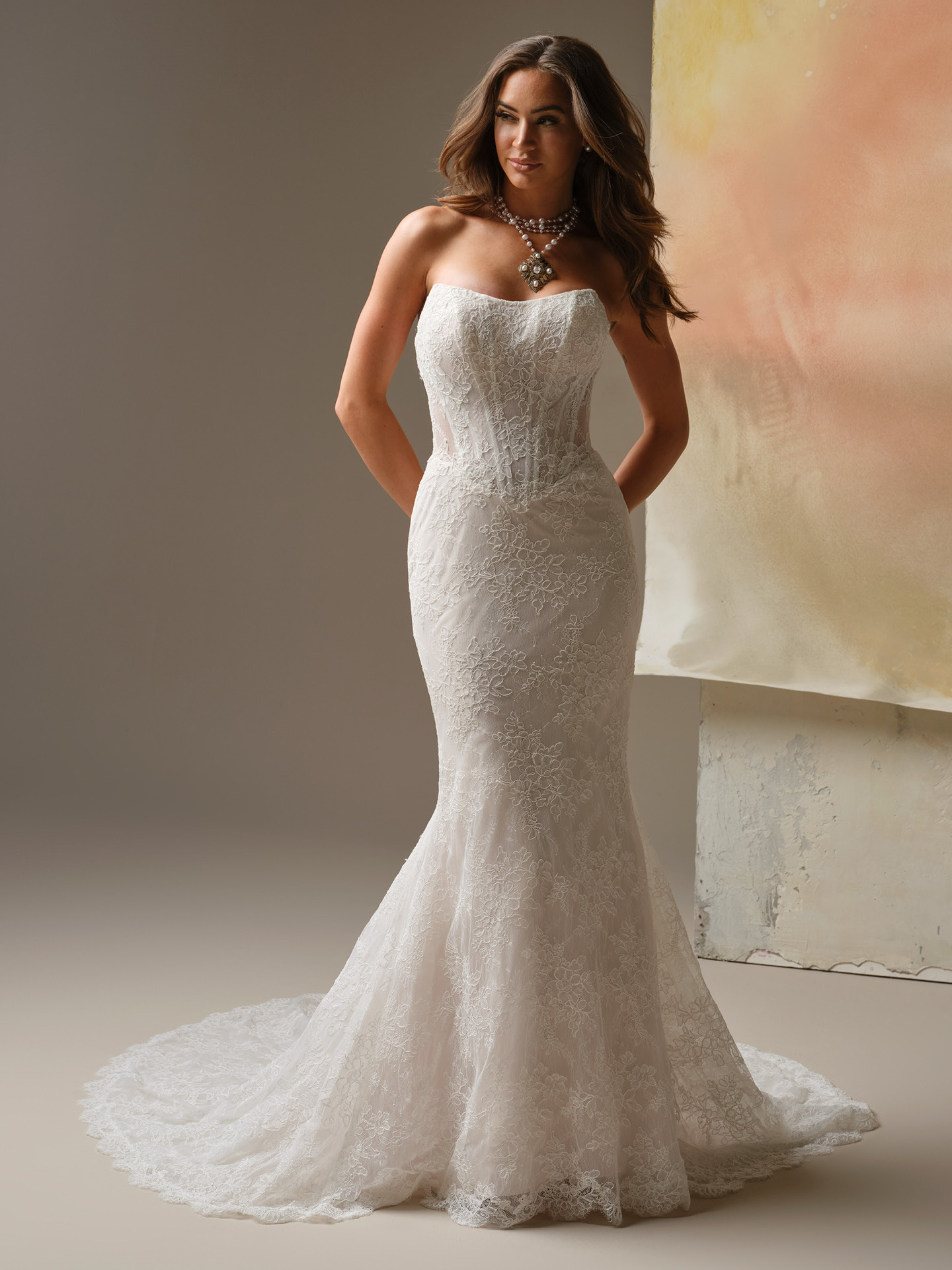 Strapless lace sheath wedding dress with sweetheart neckline and fitted silhouette featuring allover floral lace and a soft lace train.
