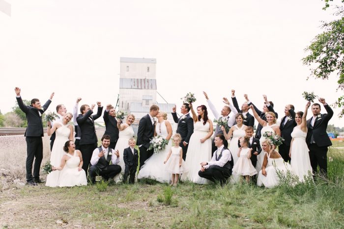 Wedding Party Cheering at Real Wedding as Bride and Groom Kiss