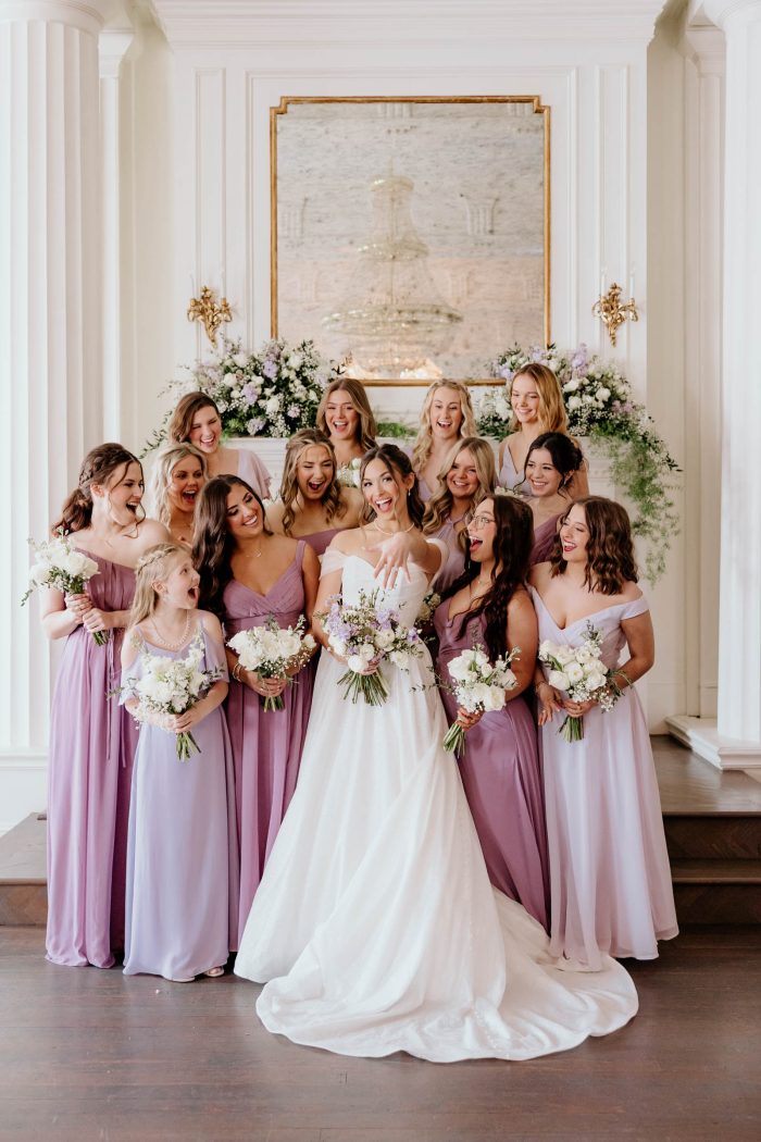 Bride wearing Anniston by Maggie Sottero with her friends wearing purple bridesmaid dresses