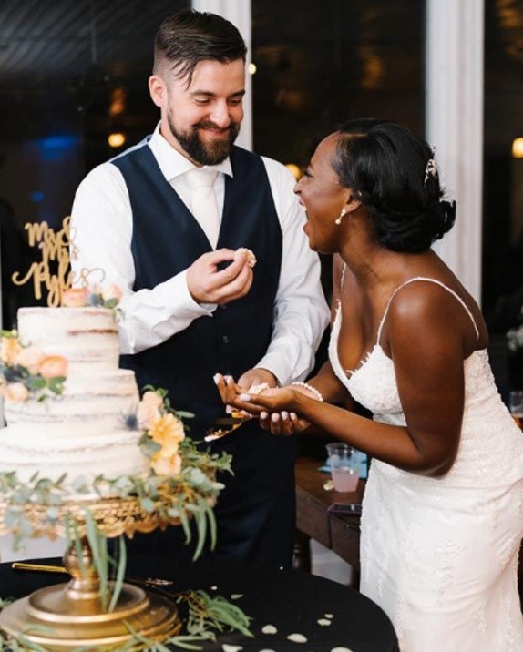 Bride and Groom eating their wedding cake wearing Nola lace sheath wedding dress by Maggie Sottero