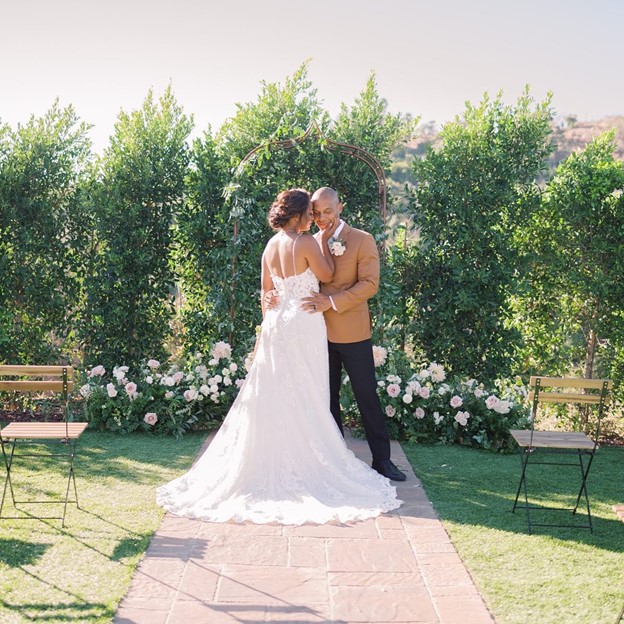 Real Bride and Groom in a Garden wearing Tuscany Lane Lace A-Line Wedding Dress by Maggie Sottero