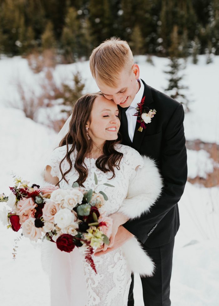 Groom at Winter Wedding with Bride Wearing Modest Lace Sheath Wedding Dress Called Tuscany Leigh by Maggie Sottero