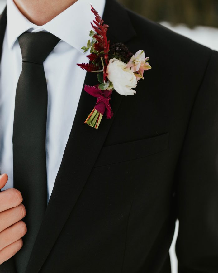 Groom Wearing Classic Black Suit and Tie with Blush and Burgundy Boutonniere