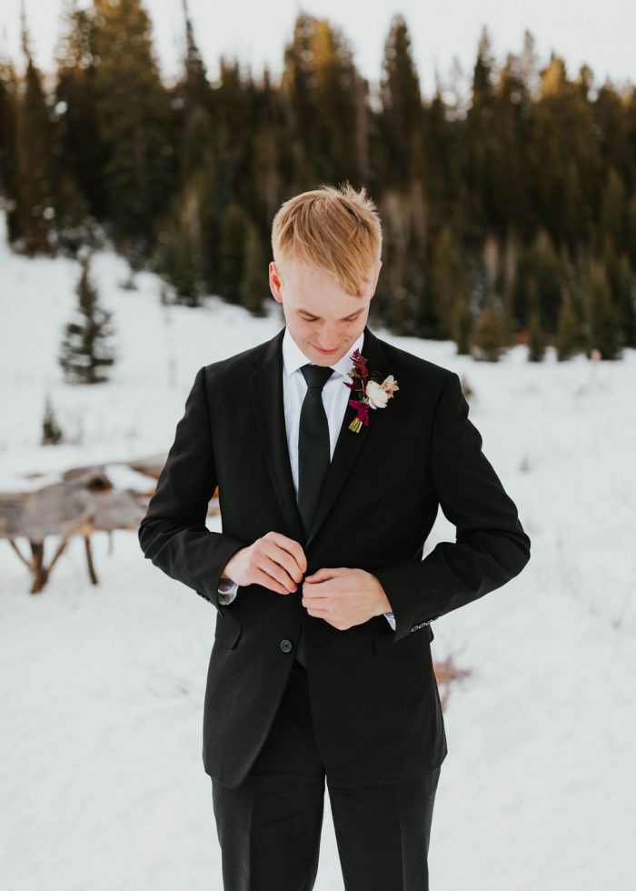 Groom Wearing Classic Black Suit and Tie with Blush and Burgundy Boutonniere