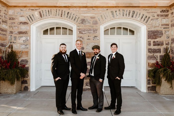 Groom Standing with Groomsmen in Black Suit and Tie Attire for a Winter Wedding