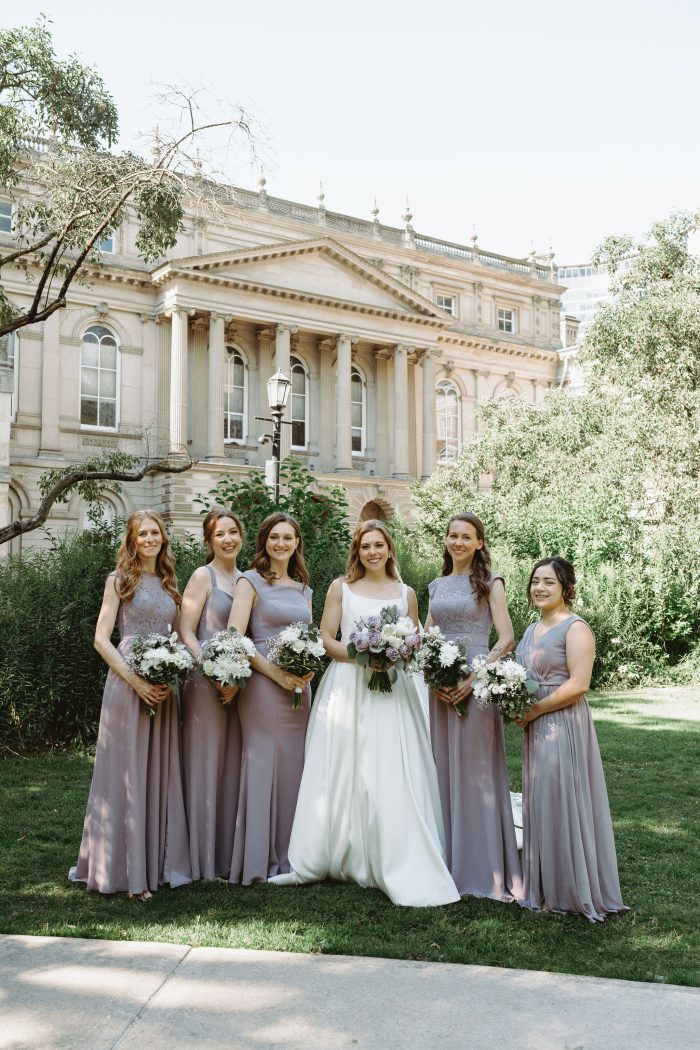 Bride wearing Selena by Maggie Sottero with her friends wearing purple bridesmaid dresses