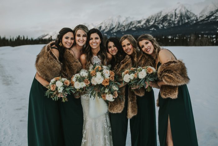 Real Bride Wearing Maggie Sottero Wedding Gown with Bridesmaids Wearing Green Velvet Dresses at Winter Wedding