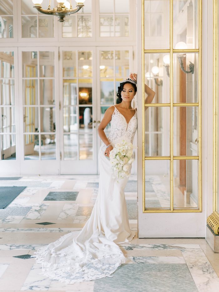 Model wearing Sophisticated Lace and Crepe Wedding Dress with a Hint of Sexy: Nikki by Maggie Sottero in a royal inspired shoot