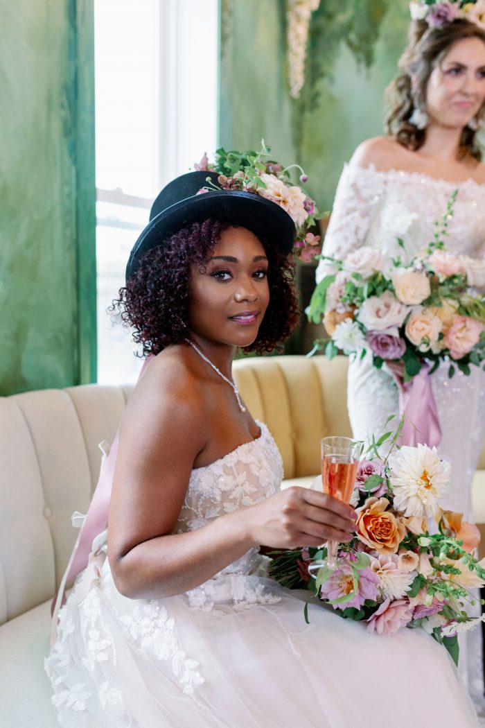 Model wearing Plus size a-line wedding dress while wearing a fun hat with pastel florals