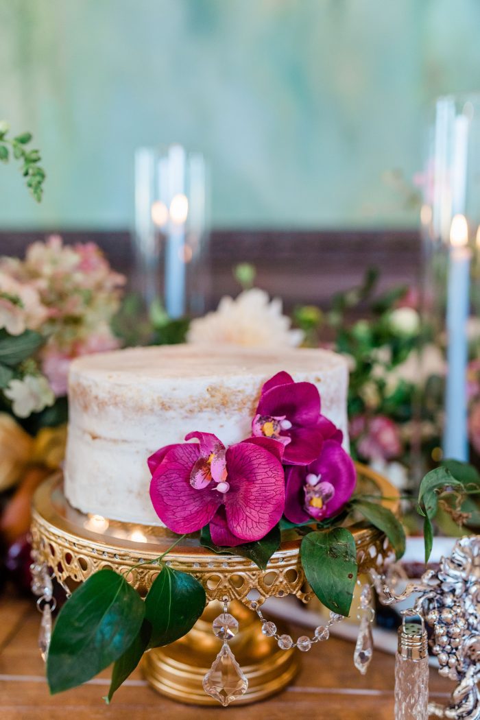 Cake with fuscia florals and gold plate