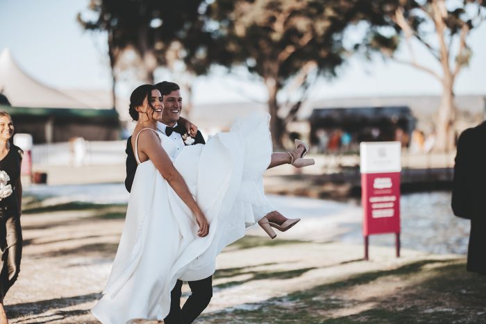 Groom Carrying Bride Wearing Satin Ball Gown Wedding Dress Called Selena by Maggie Sottero